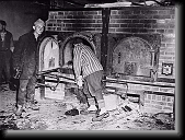 Survivors in Mauthausen open one of the crematoria ovens for American troops who are inspecting the camp. * 480 x 357 * (77KB)